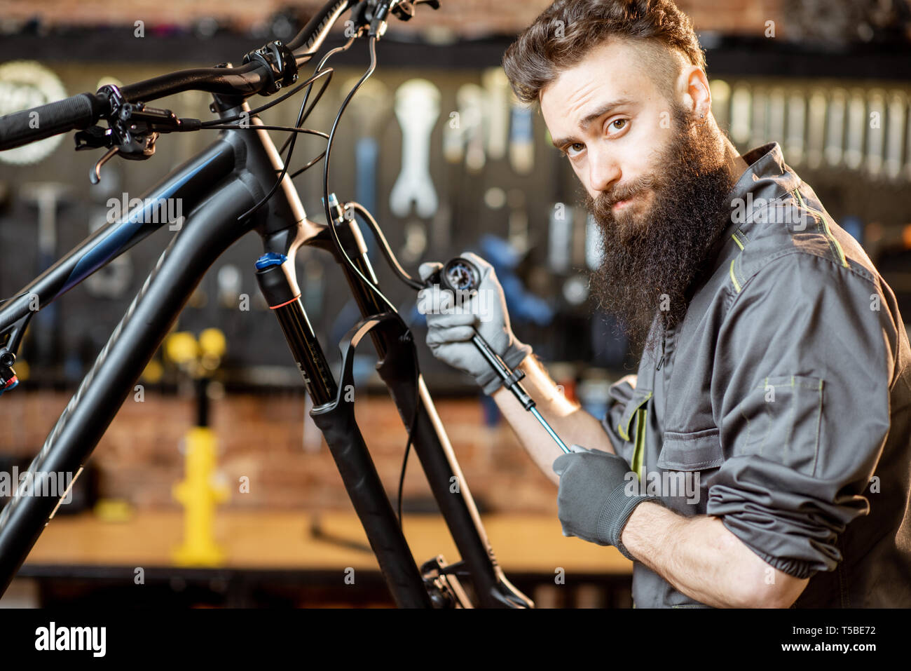 Repairman pumping shock absorber of the mountain bike in the