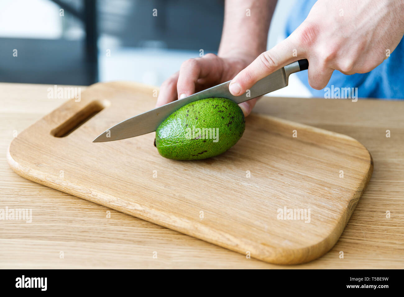 https://c8.alamy.com/comp/T5BE9W/a-young-boy-slicing-an-avocado-on-a-wooden-board-for-salad-T5BE9W.jpg