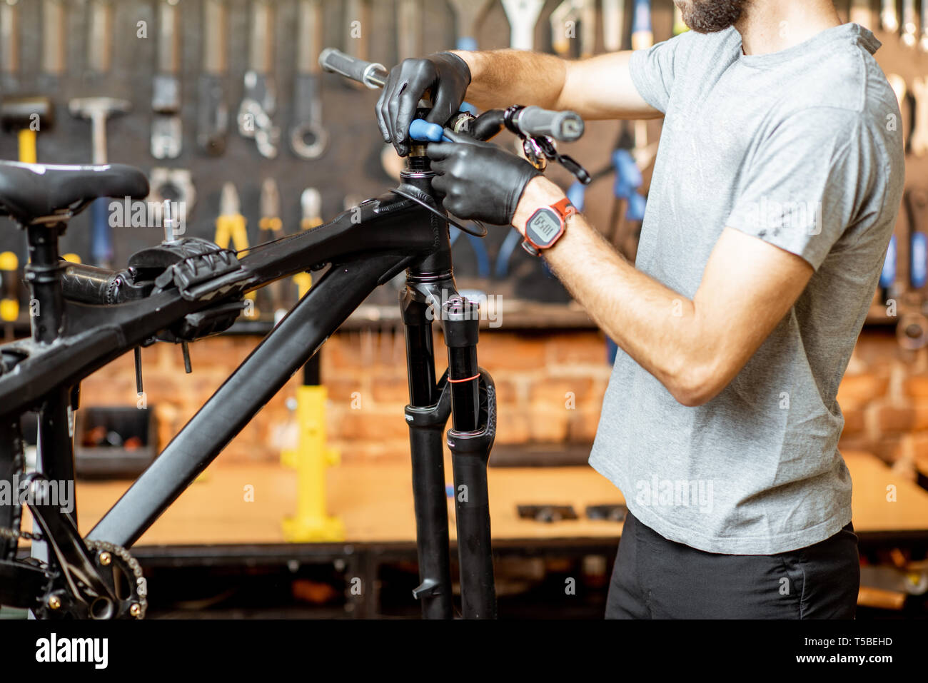 Man removing steering wheel from the bicycle at the workshop Stock Photo