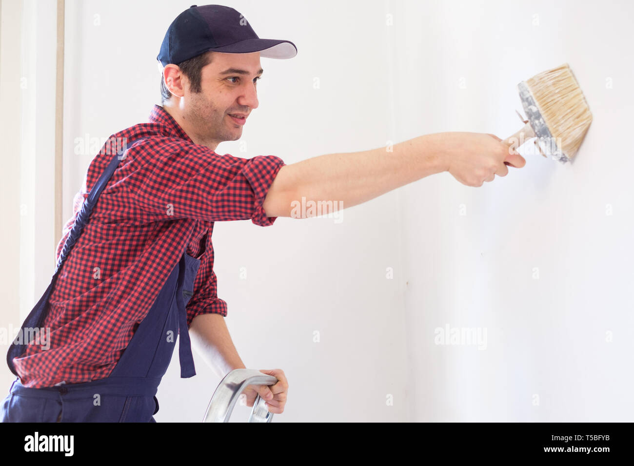 Painter man at work using brush and ladder Stock Photo Alamy