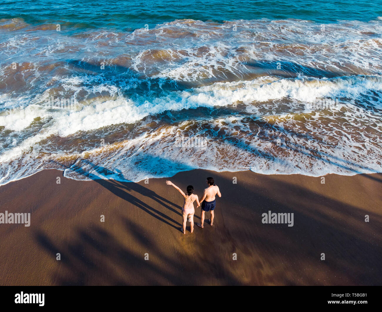 Couple holding hands on the beach aerial view Stock Photo