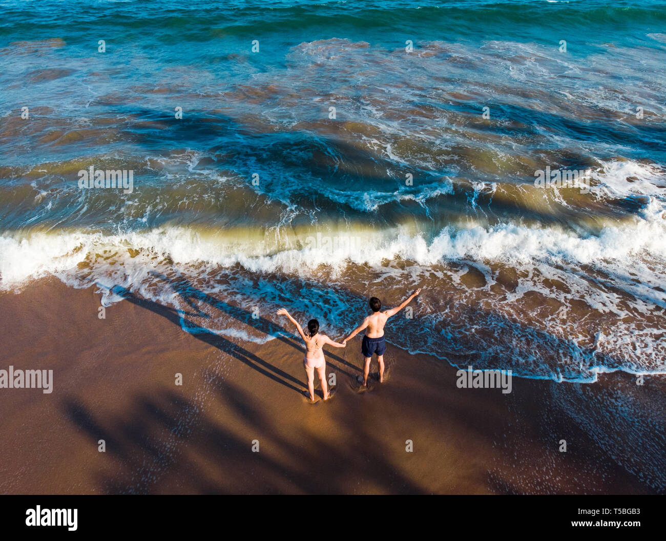 Couple holding hands on the beach aerial view Stock Photo