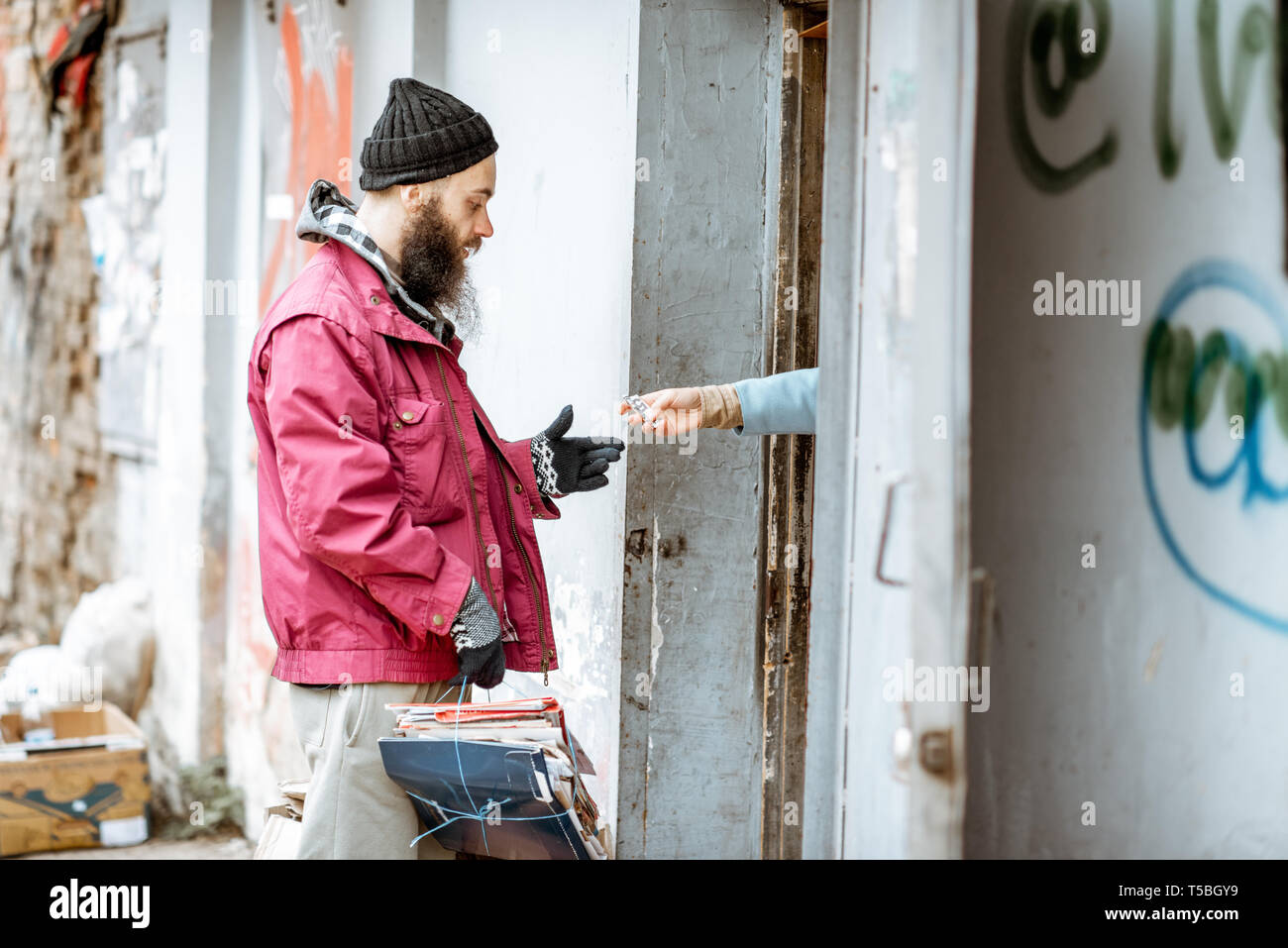 Homeless beggar bringing waste paper to the collection point, getting ...