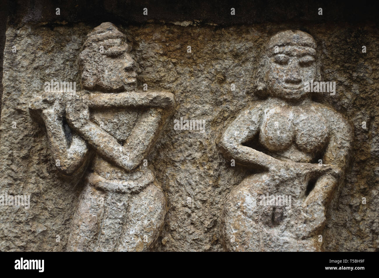 Erotic sculpture representing a couple ( India). The man is playing flute like the hindu god Krishna. Stock Photo