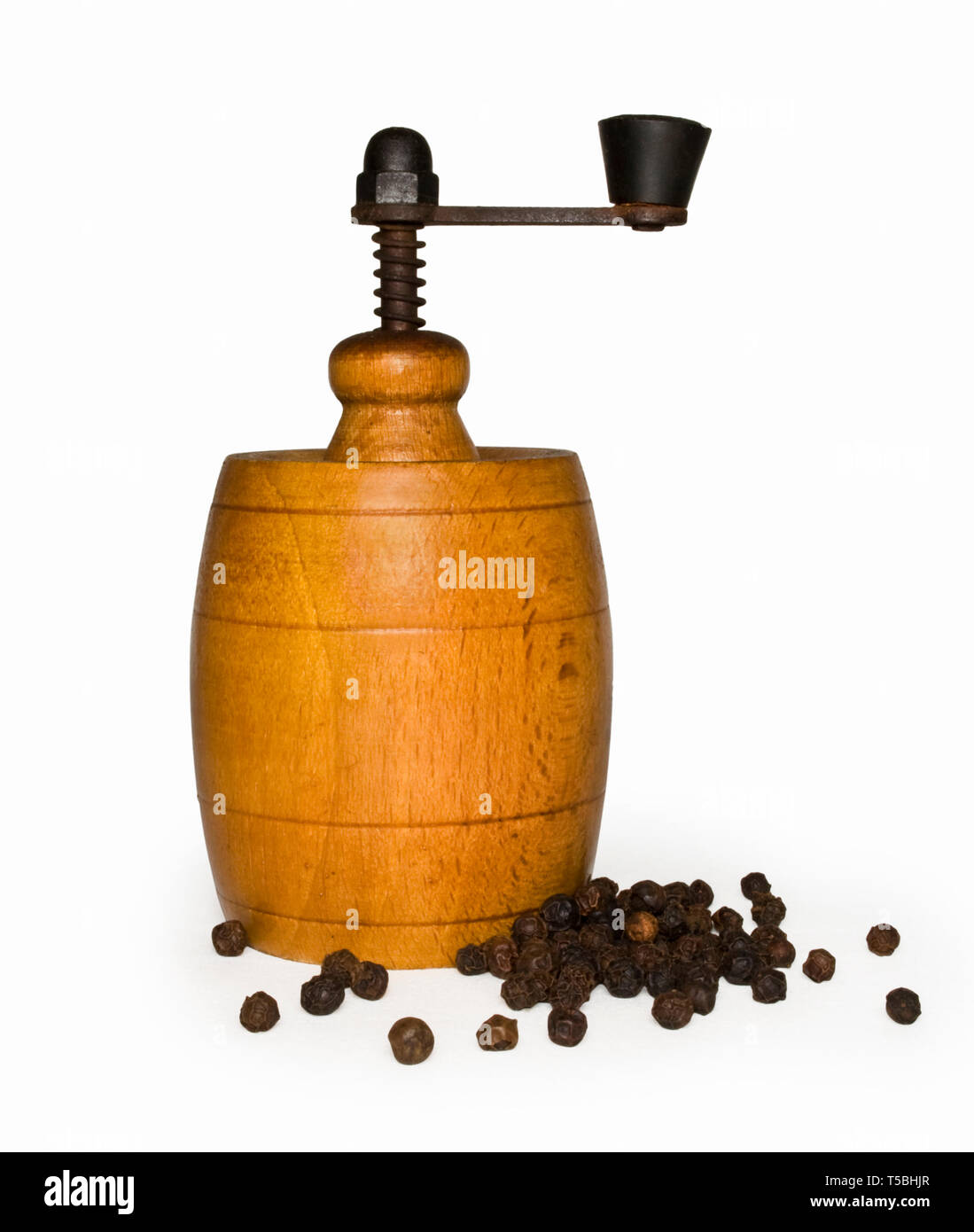 Wooden pepper mill with pepper isolated on white + clipping path Stock