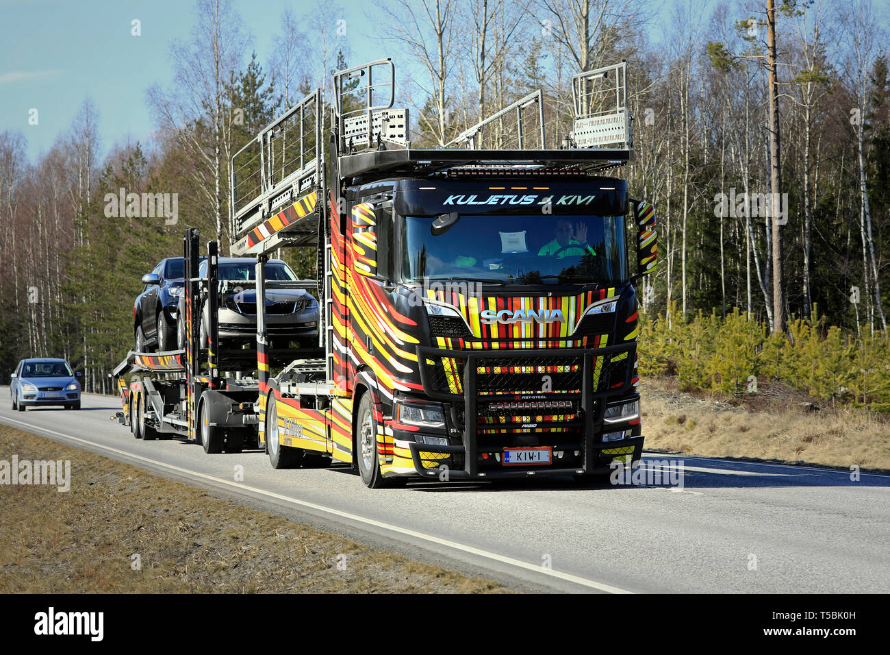 Tenhola, Finland - April 12, 2019: Unique vehicle carrier Scania R650 of Kuljetus J. Kivi hauls cars along rural highway on a day of spring. Stock Photo