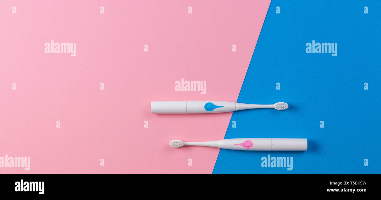 Two toothbrushes on blue and pink background. Top view Stock Photo