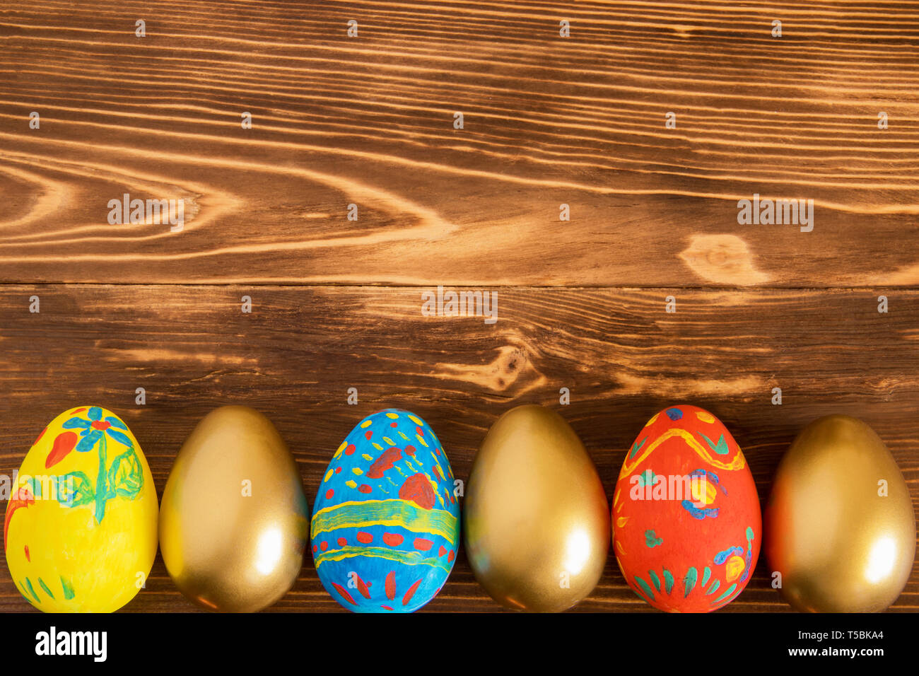 Colored Easter eggs on wooden background with copyspace Stock Photo