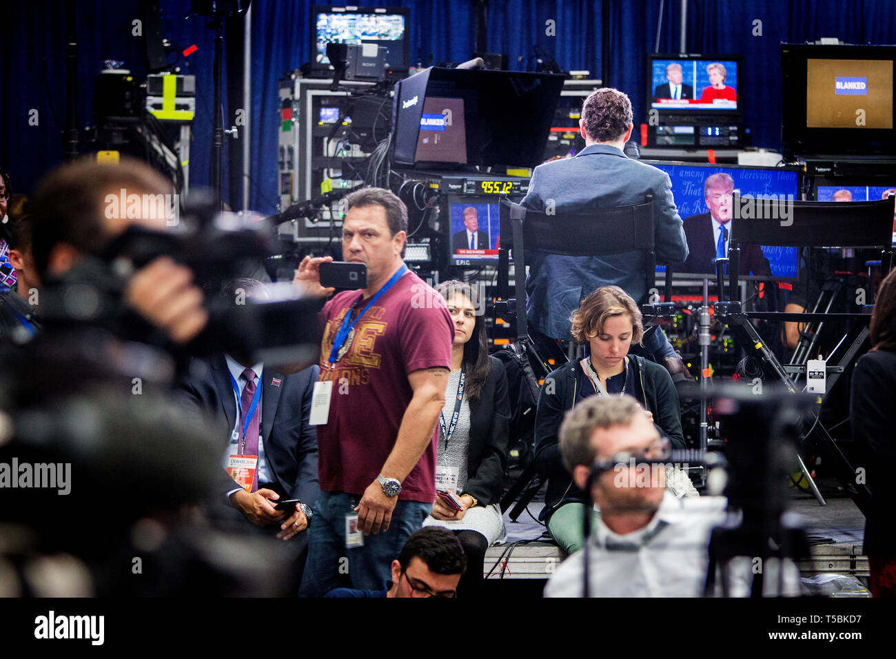 Reporters in the spin room listen to the debate. The Democrate and Republican nominees for US President, Hillary Rodham Clinton and Donald John Trump, met on Sep. 26th for the first head to head Presidential Debate at the Hofstra University in Long Island. Stock Photo