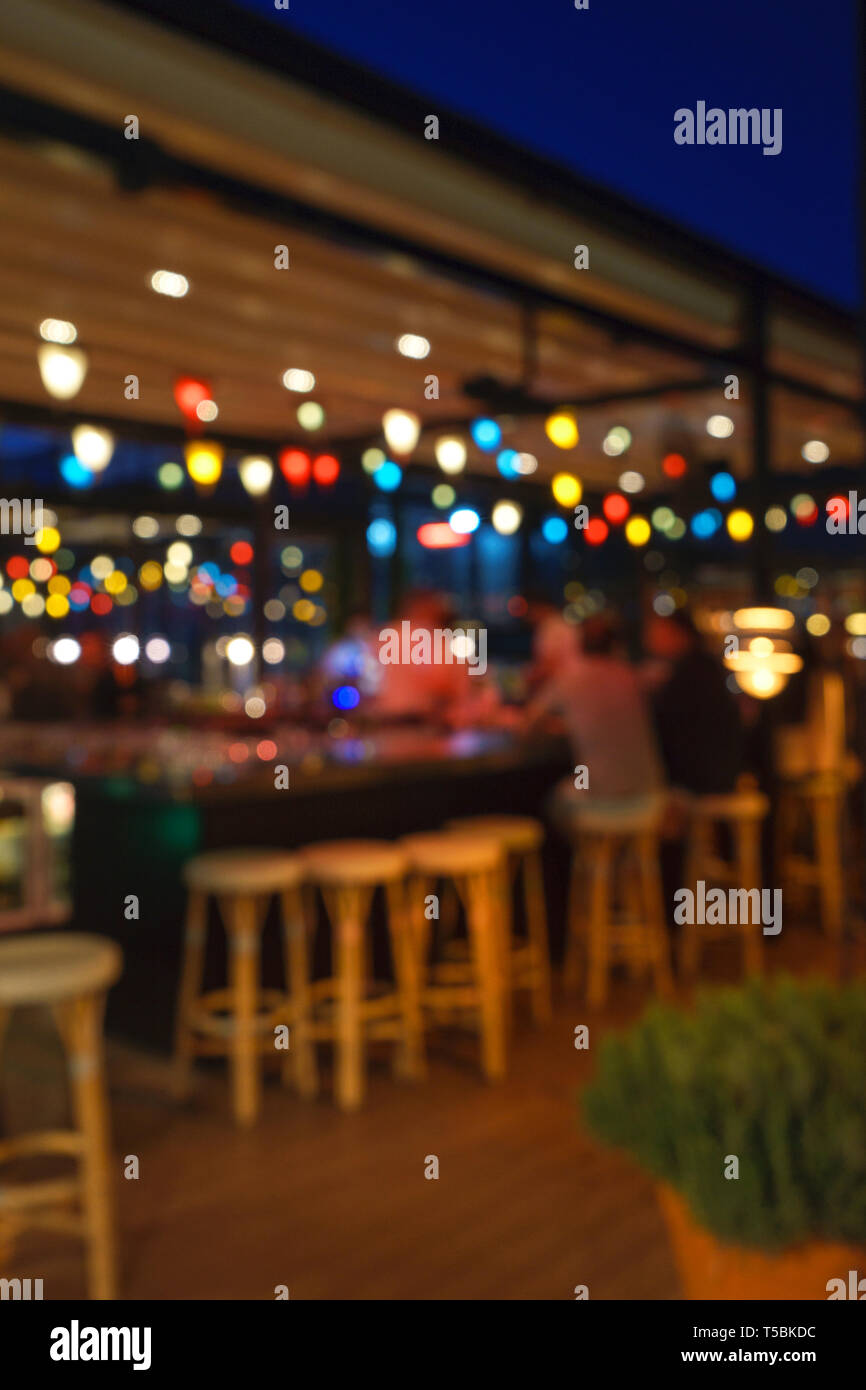 Blurred background of customer sitting at restaurant, bar or night club, with bokeh. Abstract defocused background. Stock Photo