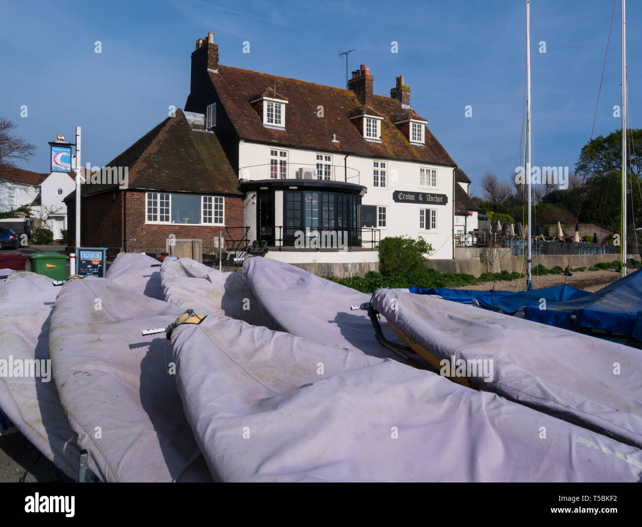 Crown and Anchor Public House and restaurant Dell Quay Marine West Sussex England UK on a lovely spring April day weather with covered paddleboards Stock Photo