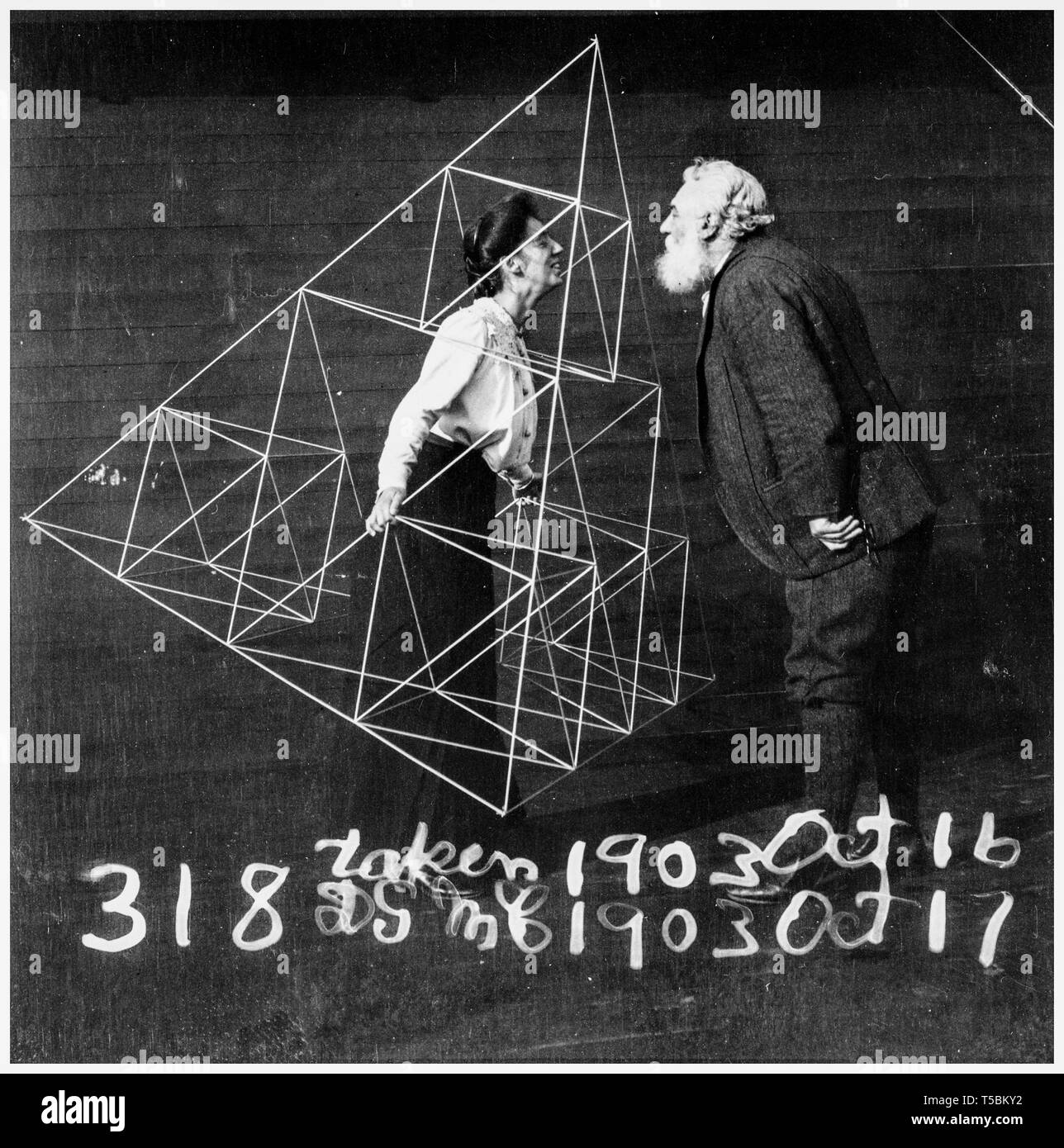 Alexander Graham Bell (1847-1922) facing his wife, Mabel Hubbard Gardiner Bell, who is standing in a tetrahedral kite, 1902 Stock Photo