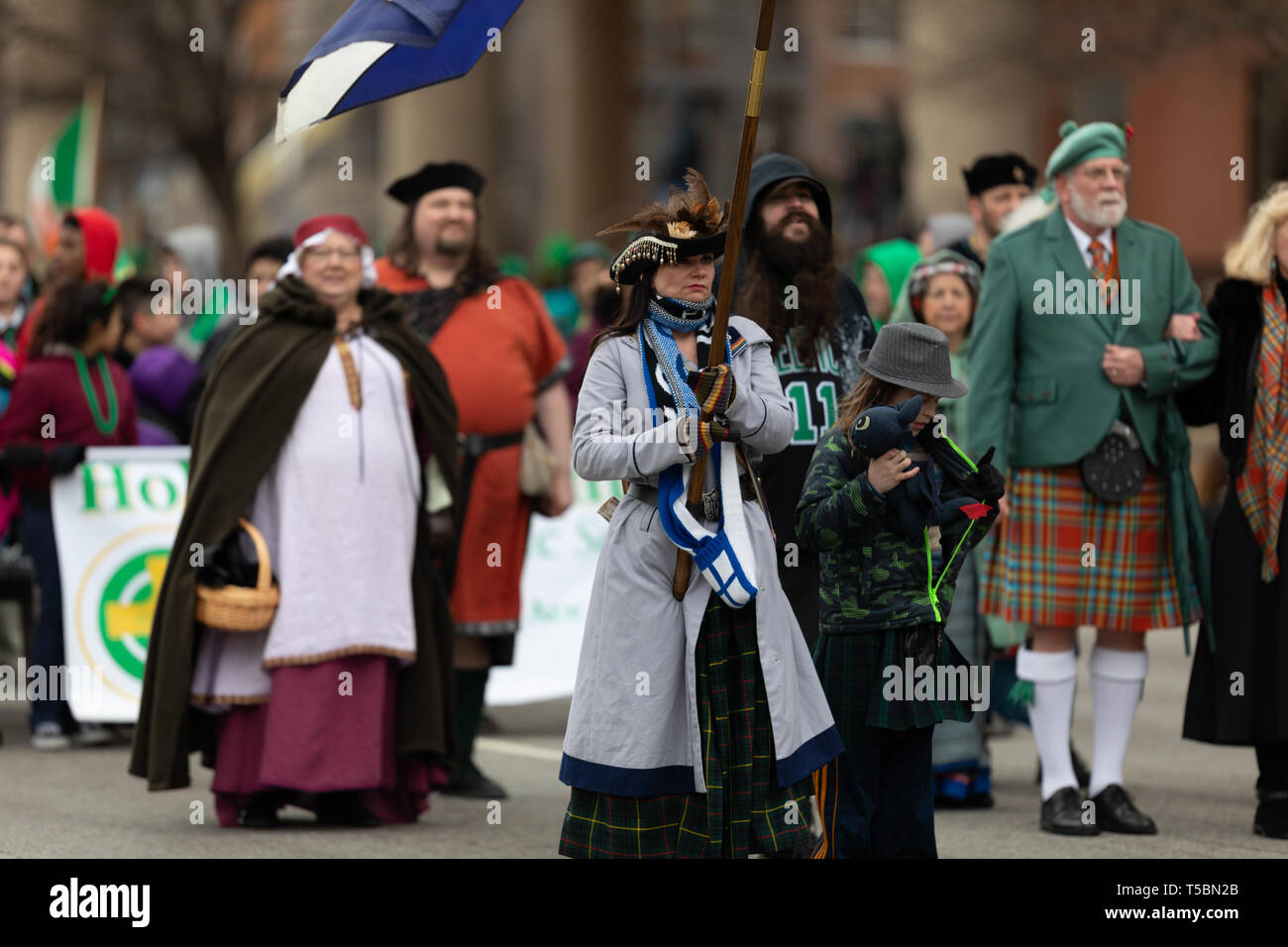 Indianapolis, Indiana, USA - March 15, 2019: St. Patrick's Day Parade, Men and women dress up in traditional Scottish clothing walking down the road d Stock Photo