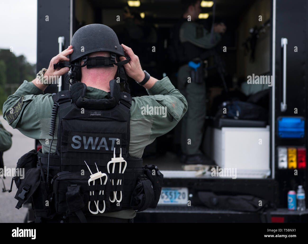 A member of the Charleston County S.W.A.T. team dons his gear for a joint training exercise with Citadel cadets and 628th Security Forces Squadron April 12, 2019, on Naval Weapons Station-Charleston. The intent of the operation was to execute defense support to civil authorities. The training focused on developing leadership and troop leading procedures, interagency interoperability, hands-on experience, communication, collaboration and building cohesion while demonstrating capabilities. Stock Photo