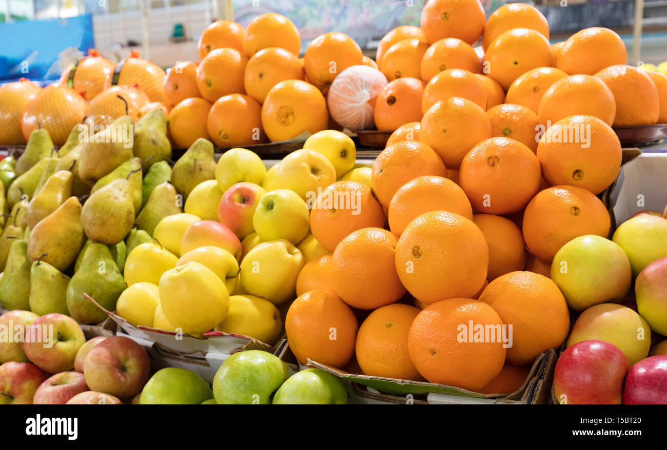 Bright background of fresh fruits. Oranges, apples, pears lie in the