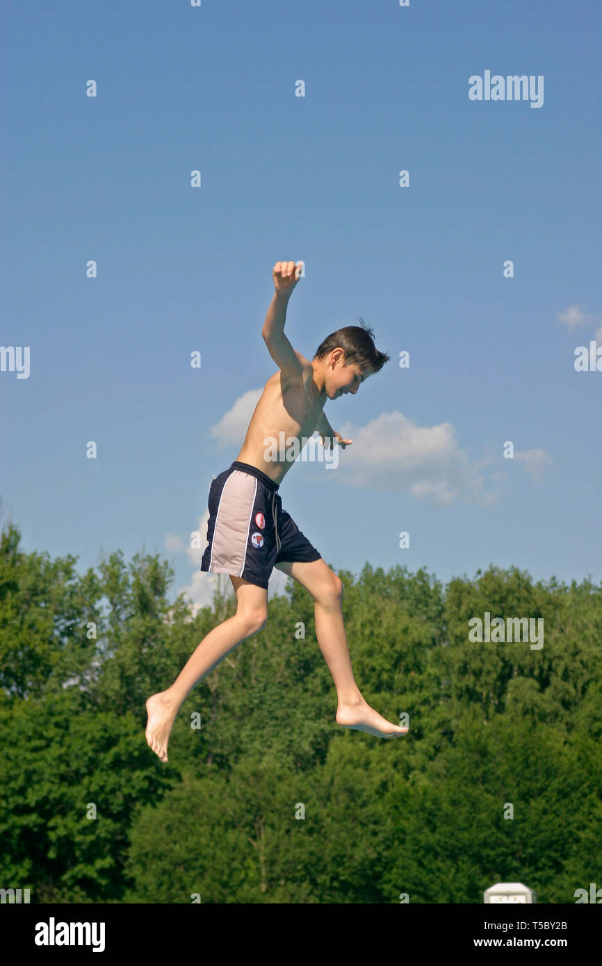 young boy jumping off a diving board Stock Photo Alamy