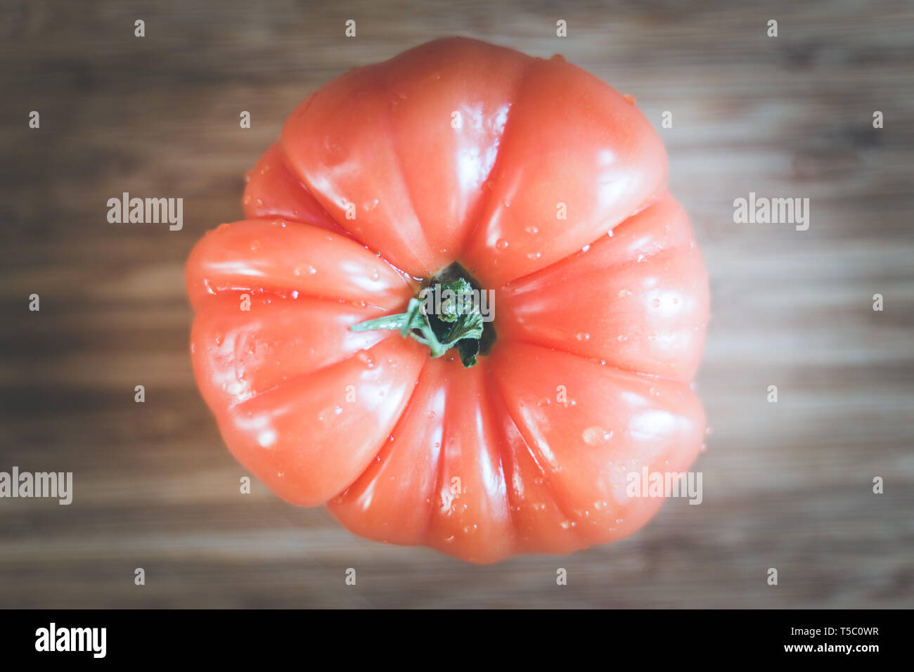 Close up picture of oxheart tomato on a bamboo wood plate. Stock Photo