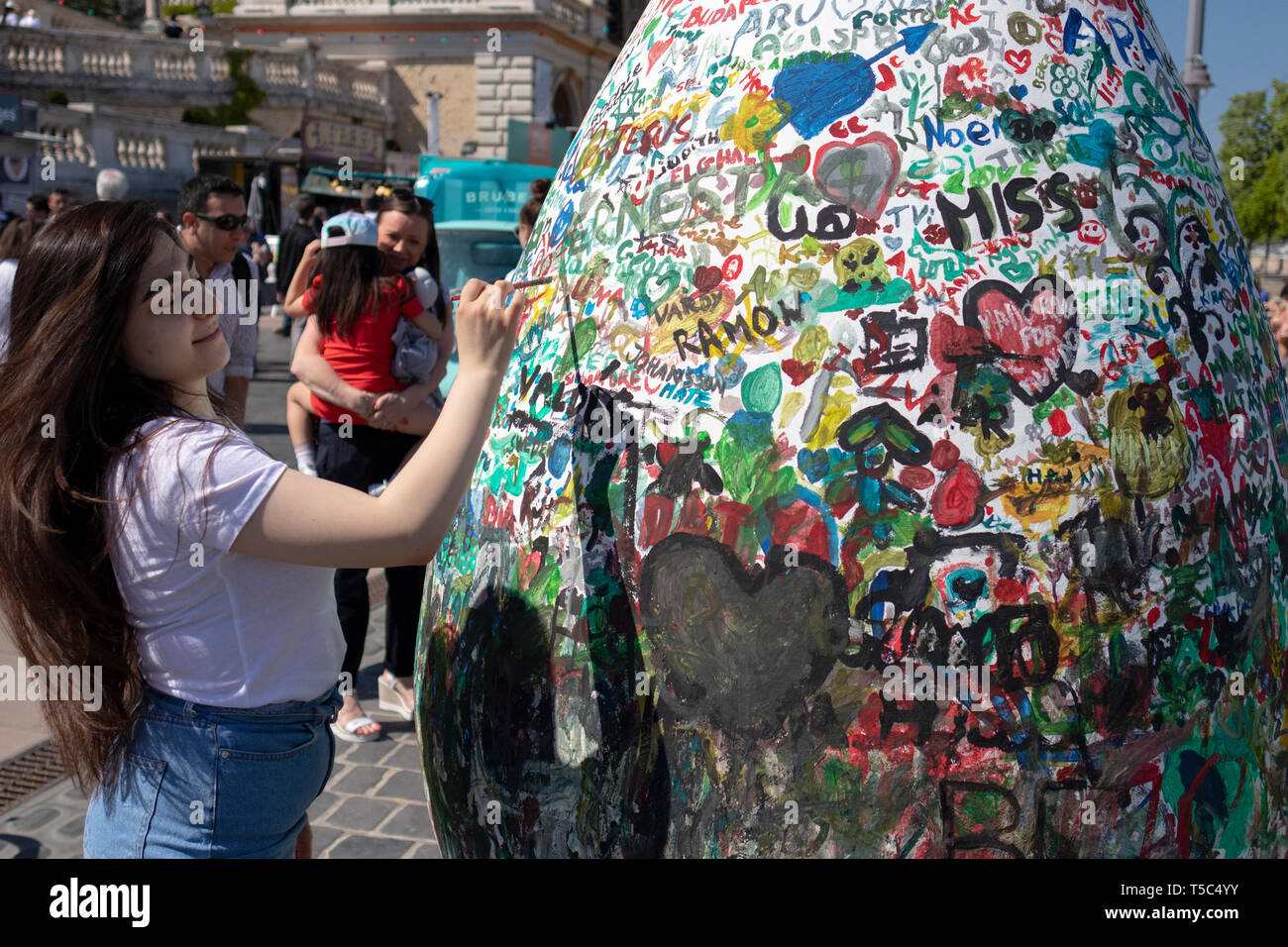 BUDAPEST/HUNGARY - 04.21.2019: A young woman tags a giant public Easter Egg. Varkert Bazar, Buda Castle. Stock Photo