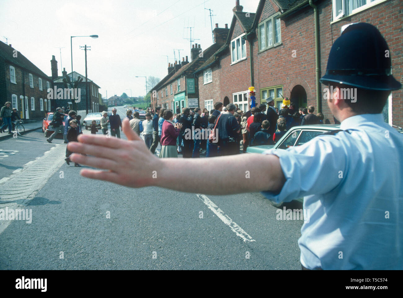 A policeman holds up traffic for Hungerford Hocktide UK in 1982 Stock Photo