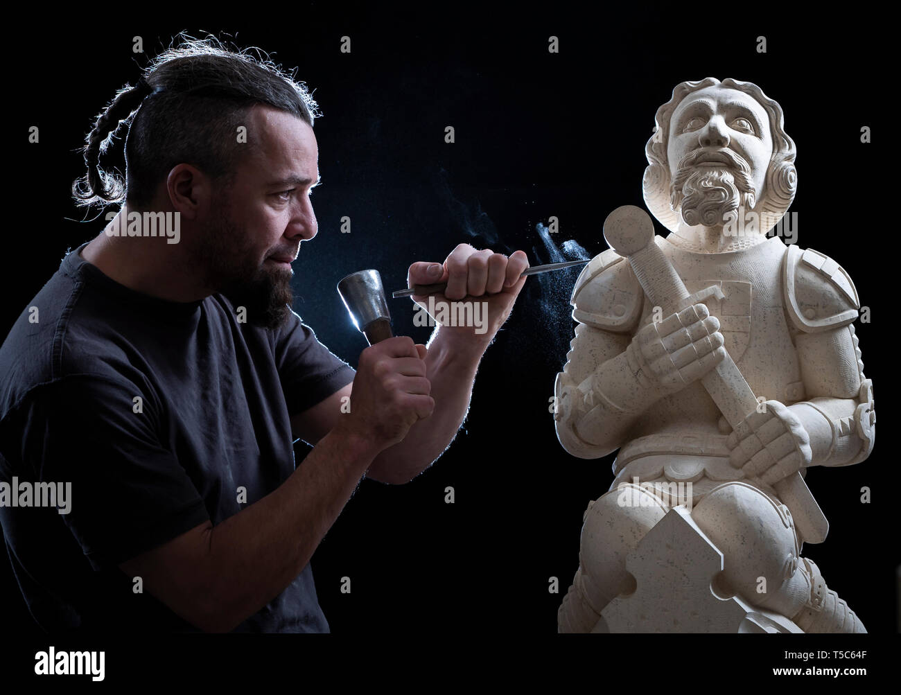 York Minster stonemason Richard Bossons adds the finishing touches to a newly-carved grotesque of St George to mark the Patron Saint's day, at the cathedral in York. Stock Photo