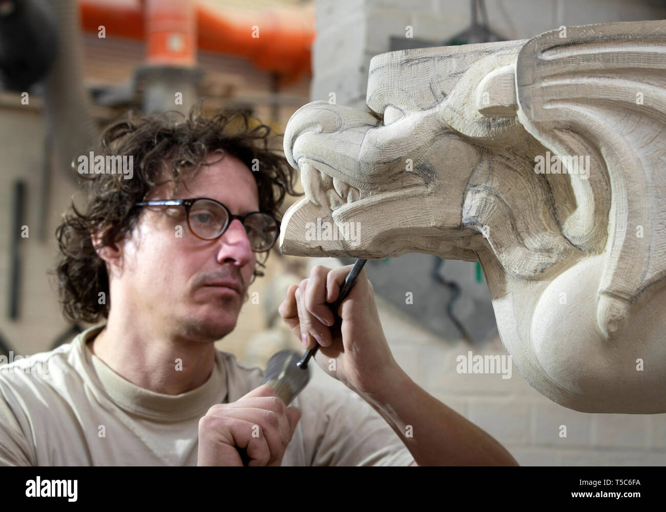 'York Minster stonemason Lee Godfrey works on grotesque during an 11 year, £11 million project to conserve and restore the cathedral's 14th century South Quire Aisle. Stock Photo