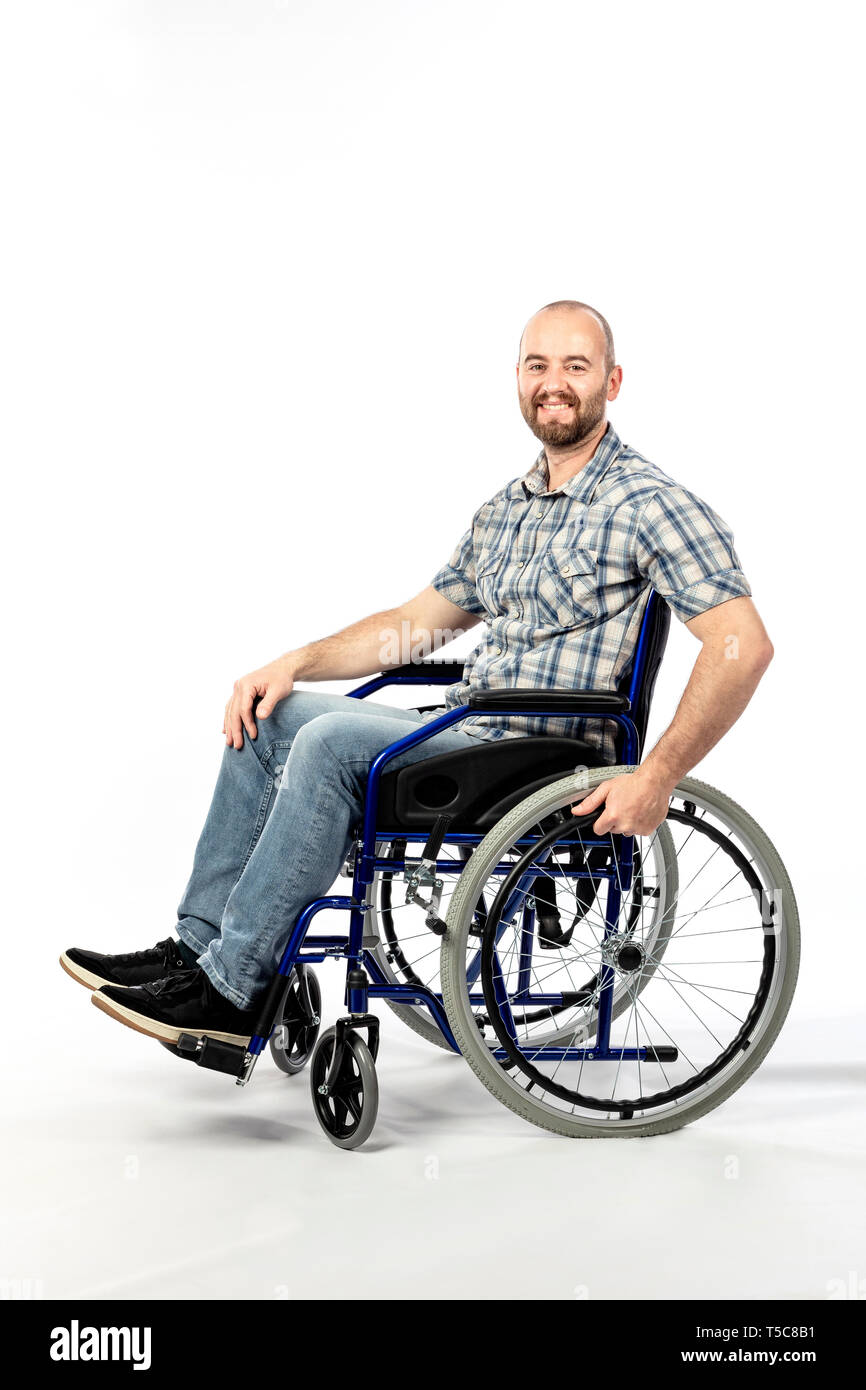 portrait of a smiling man sitting on a wheelchair and engaged in physical rehabilitation following an injury. Stock Photo