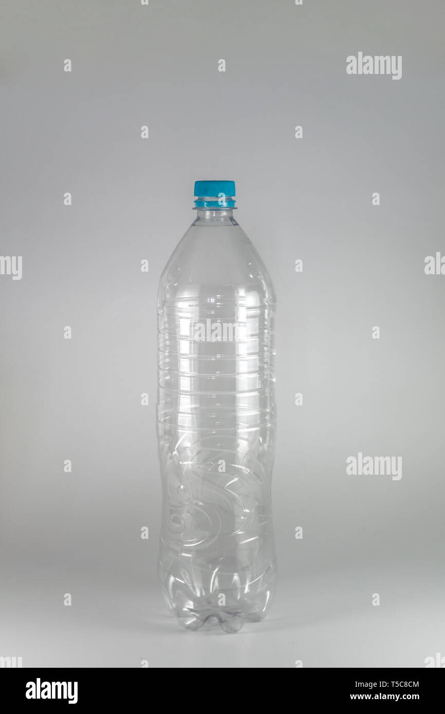 A empty bottle of a liter and a half of mineral water with blue cap and sealing ring on a white background, and space for inserts. Reuse, Eco-Friendly Stock Photo