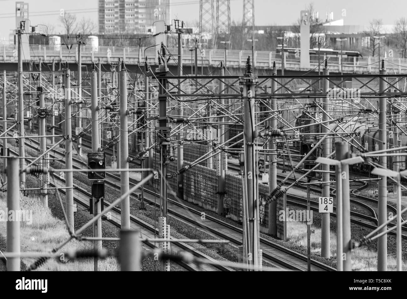 Wolfsburg, Germany, March 5., 2019: Surrealistic black and white image of power lines, rails, current collectors and track systems at a marshalling ya Stock Photo