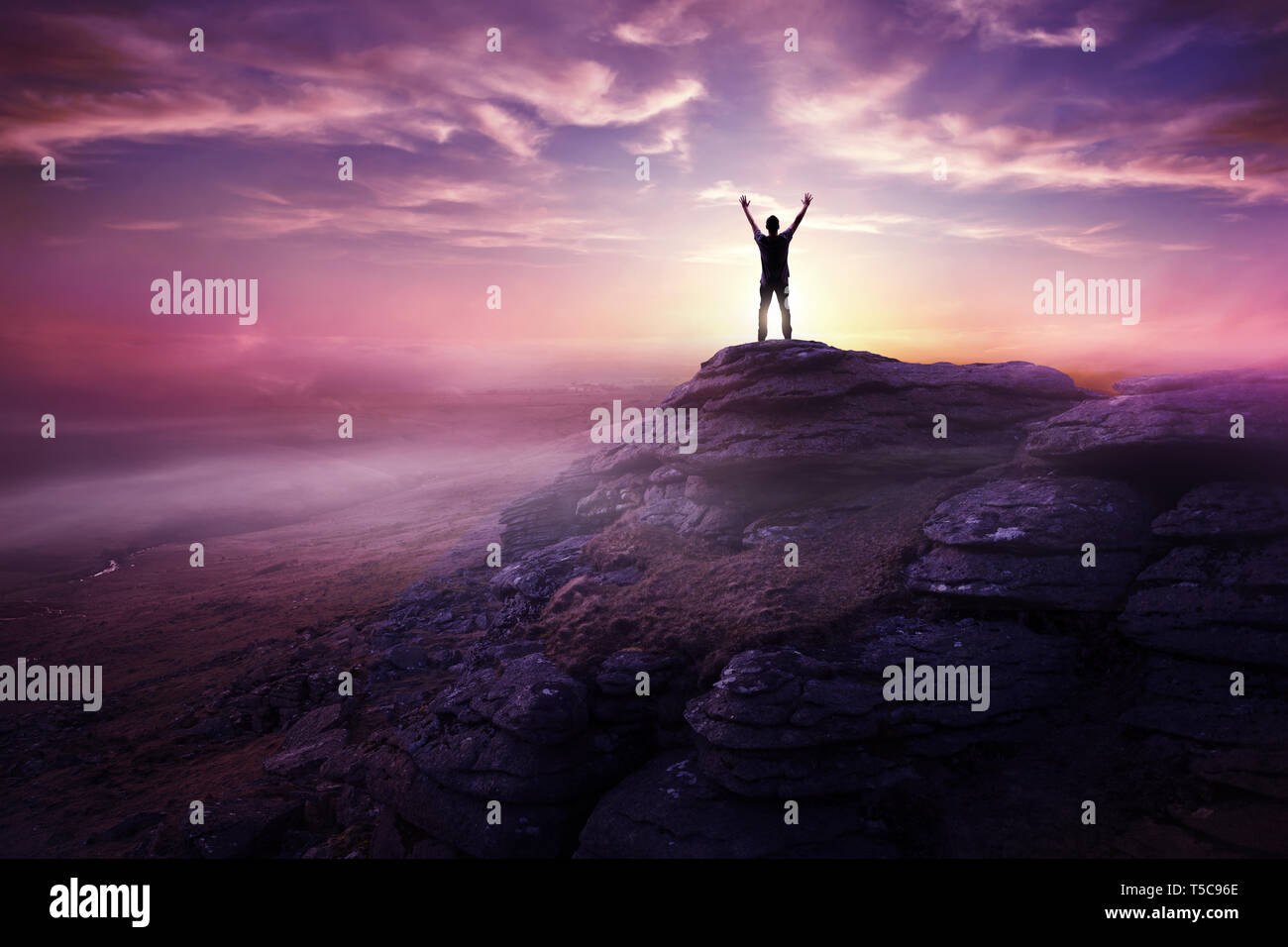 A man expressing freedom by reaching up to the sky as the sun sets in the distance. Hopes and dreams photo composite. Stock Photo