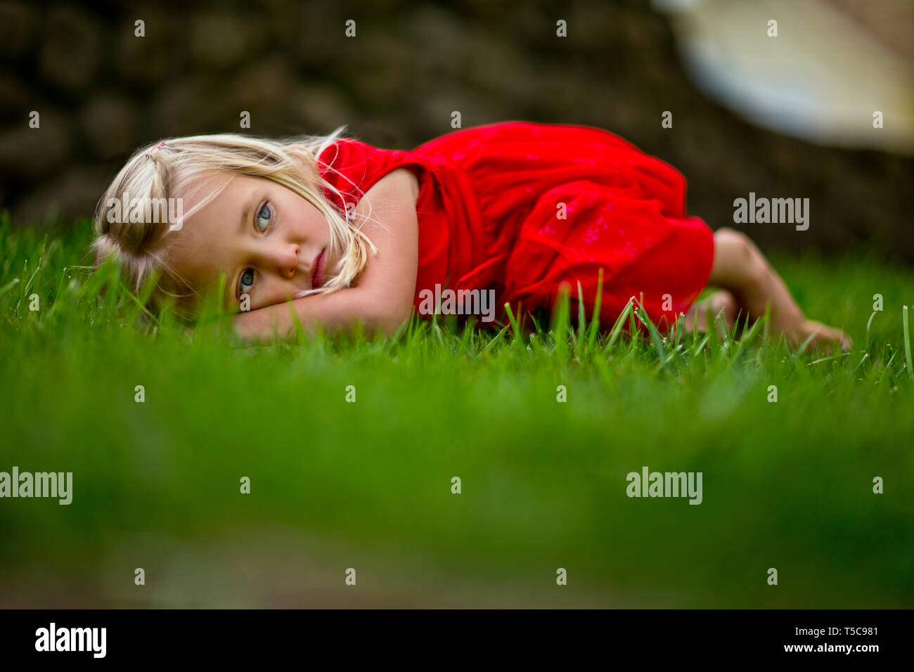 Young girl lying on green grass Stock Photo - Alamy