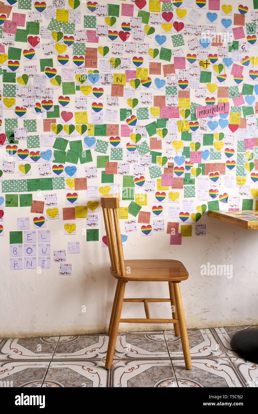 Multicolored postcards pasted on interior of unusual cafe Stock Photo