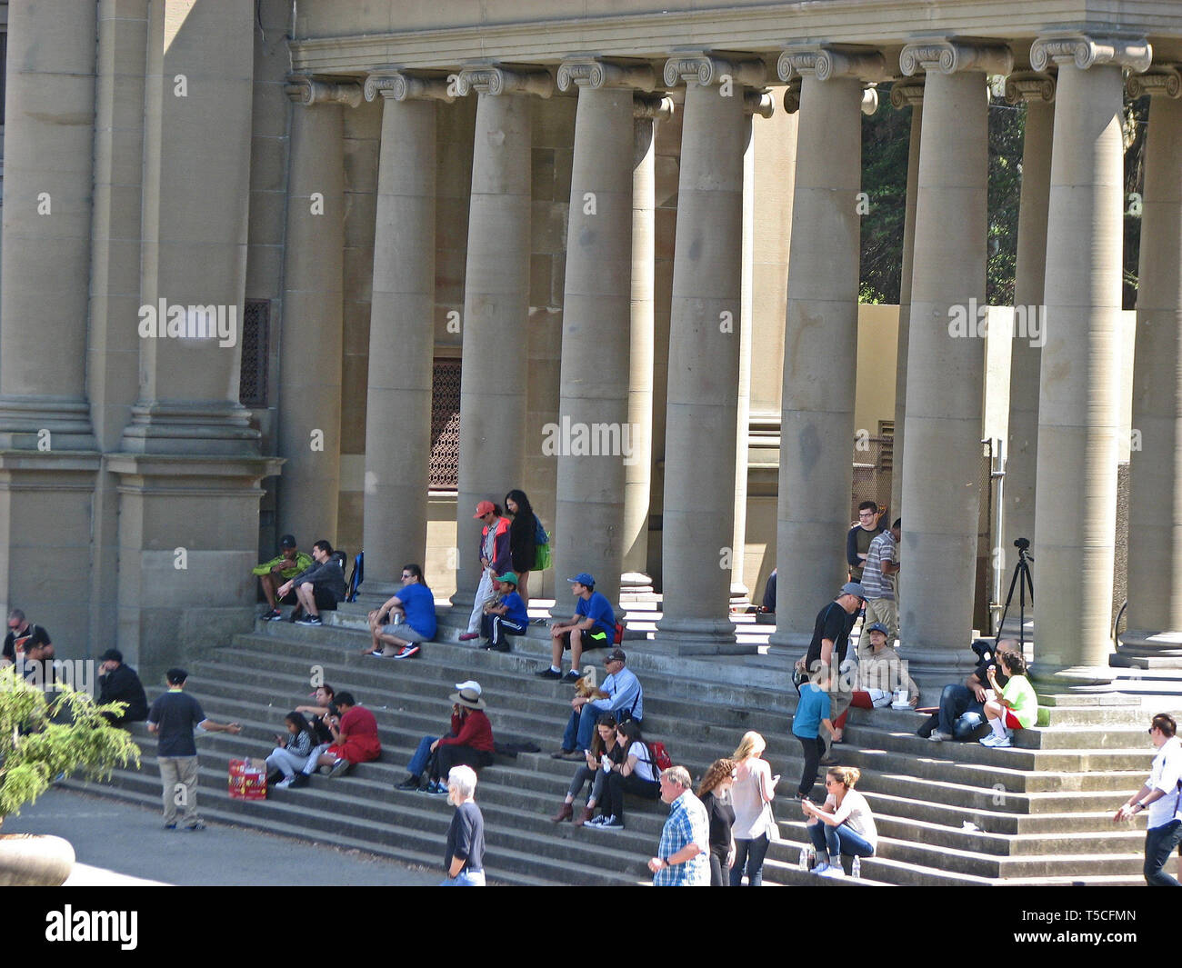 A crowd of people sit on the steps of a building in San Francisco. Stock Photo