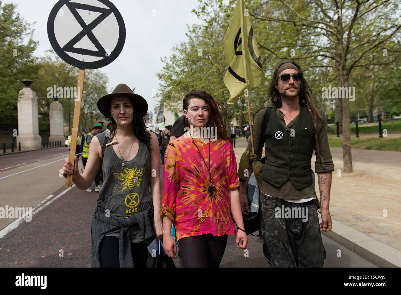 Climate Change protesters are seen holding a placard and a flag with the Extinction Rebellion logo during the Extinction Rebellion march in London.  Extinction Rebellion protesters march from Marble Arch to Parliament Square, attempting to deliver letters to their MPs. Extinction Rebellion activists were permitted to be in Parliament Square but not to enter Parliament. After several attempts to deliver the letters, the activists reached an agreement with MPs through the police. Ten activists were allowed to deliver the letters in the company of Baroness Jenny Jones (Green party). Philosopher a Stock Photo