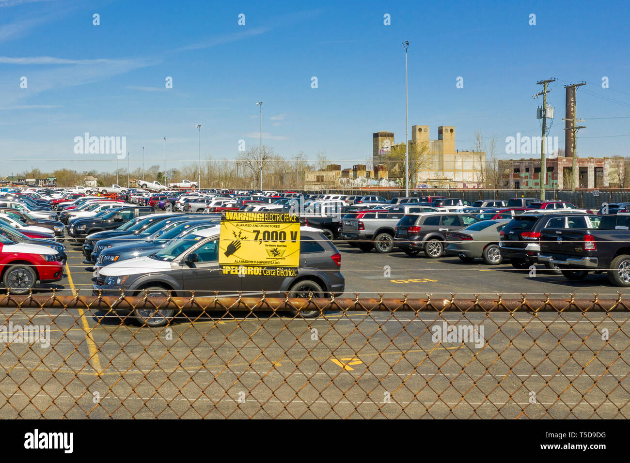 Detroit, Michigan - Trucks and cars built by Fiat Chrysler awaiting transport to dealers at Cassens Transport's Connor Yard. A sign warns that an elec Stock Photo