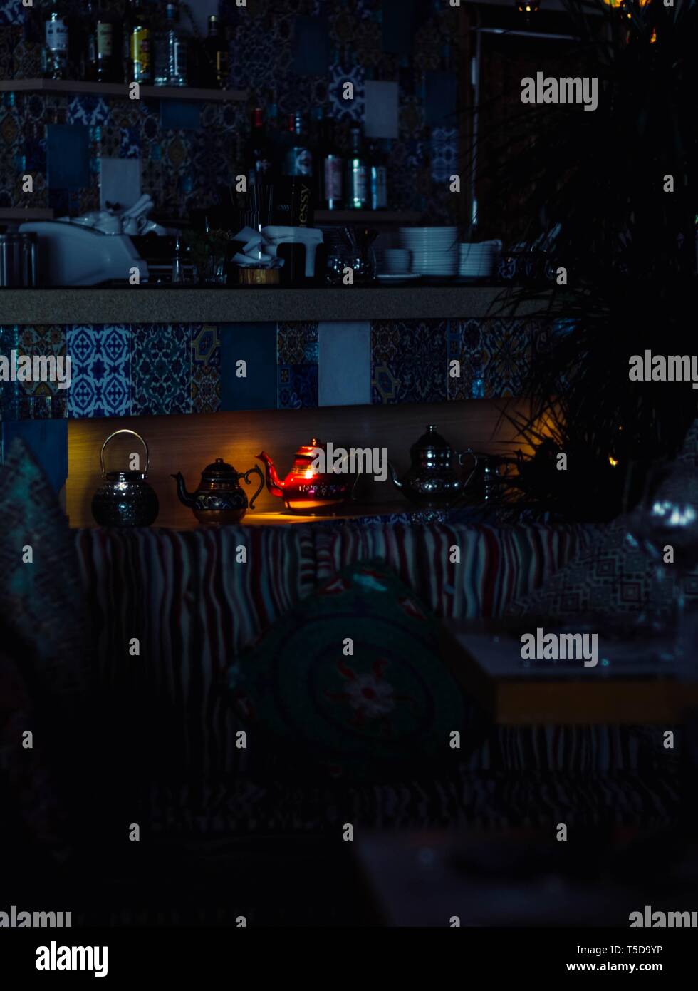 Fancy Teapots In A Dark Room With A Little Light On A Red