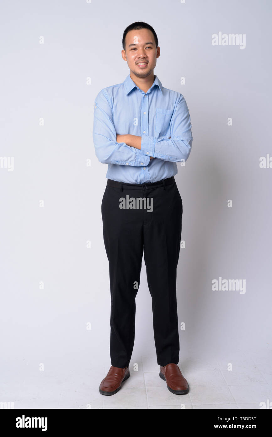 Full body shot of happy young Asian businessman smiling with arms ...