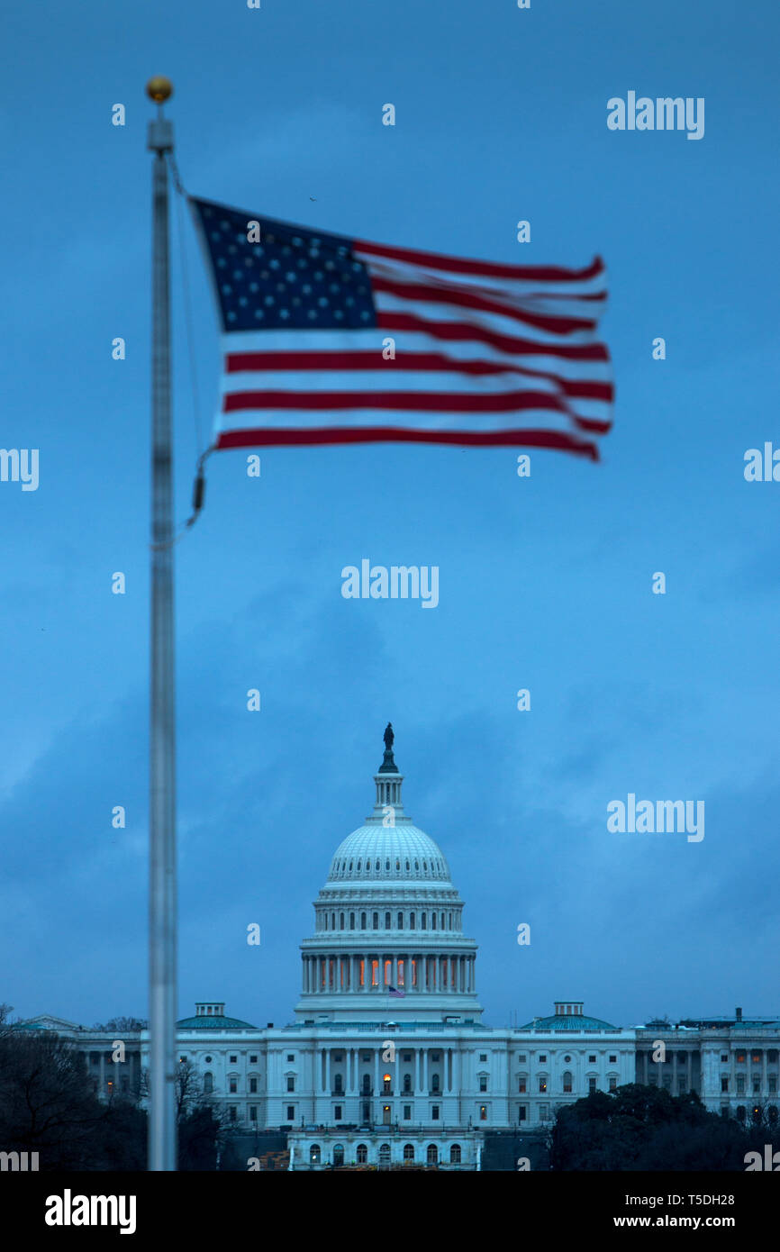 An American flag in front of the US Capitol Building on Capitol Hill. The Congress Building is divided into the Senate and the House. Stock Photo