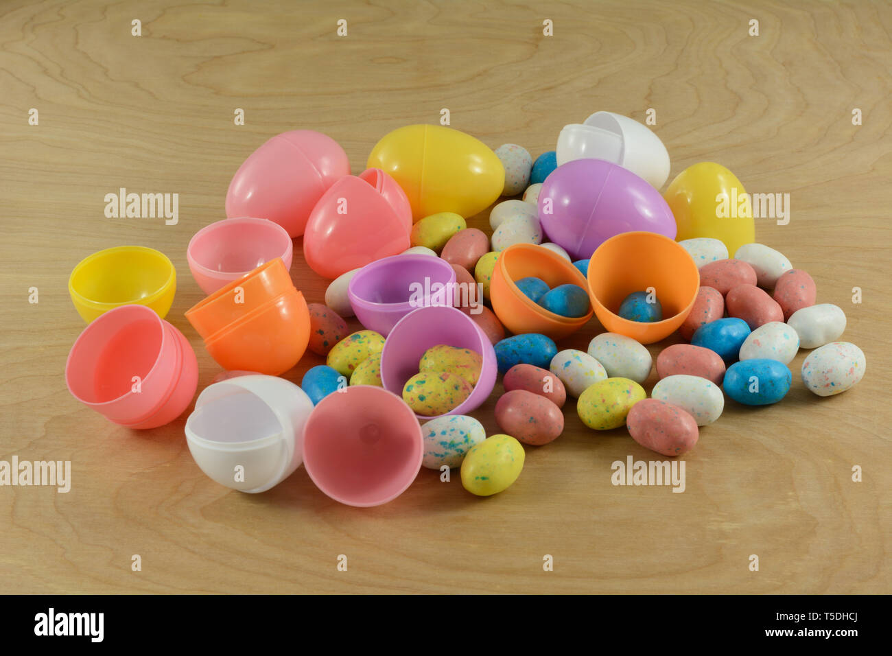 Preparing for Easter egg hunt by putting candy covered malted milk balls in shape of bird eggs into eco-friendly recyclable plastic Easter eggs made f Stock Photo