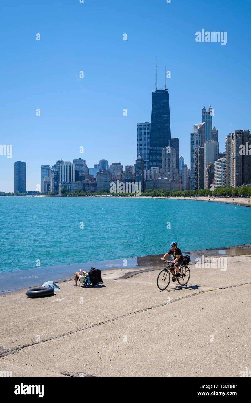 People enjoying a sunny day by sunbathing and cycling at Michigan