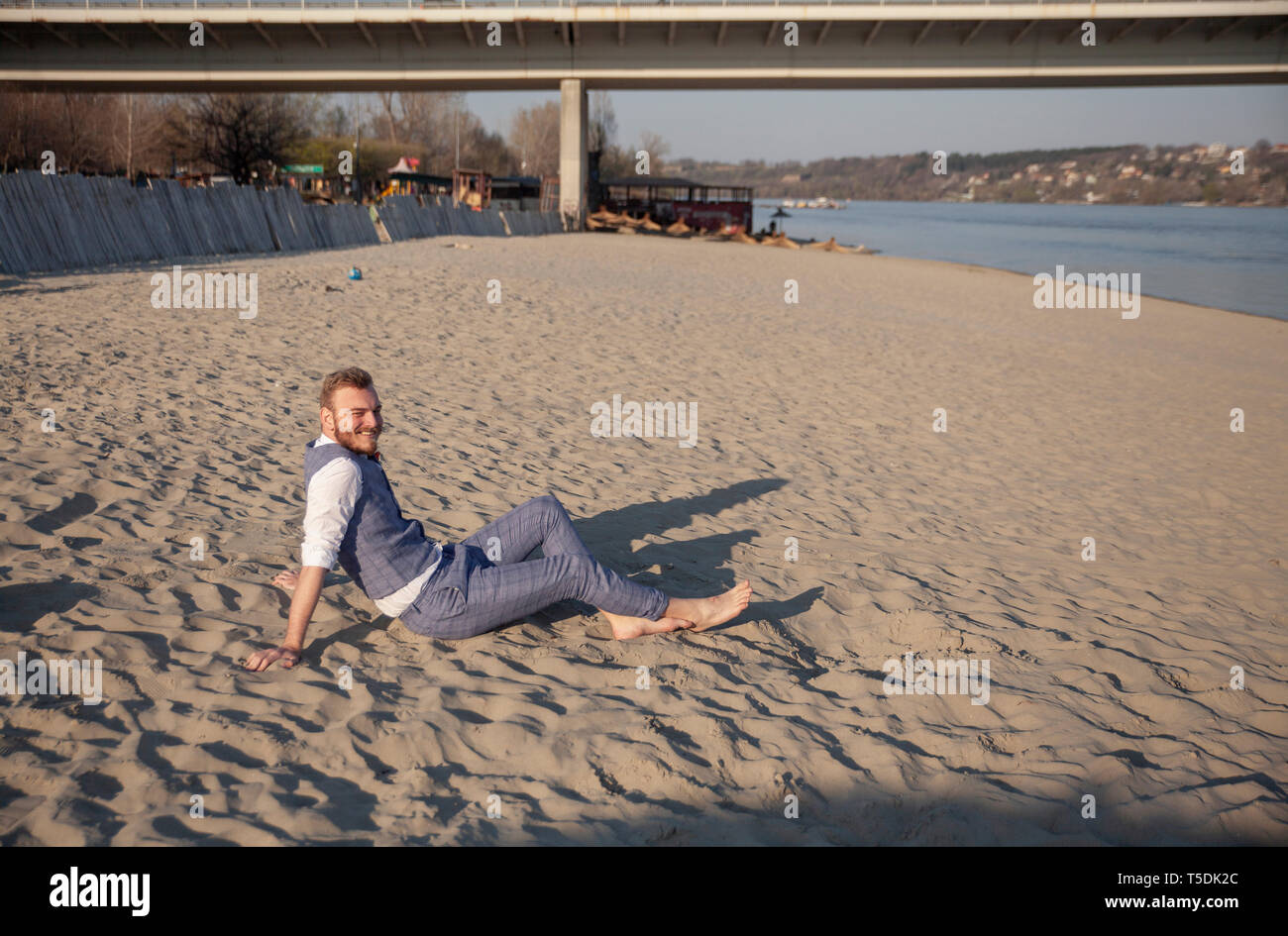 one young man, smiling, laying on beach relaxing. Stock Photo