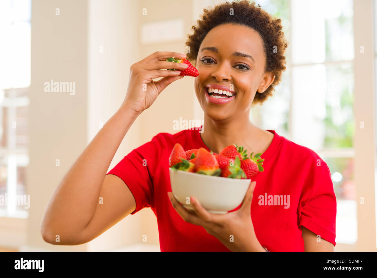Beautiful young african woman with afro hair eating fresh strawberries Stock Photo - Alamy Beautiful young african woman with afro hair eating fresh strawberries Stock Photo - Alamy