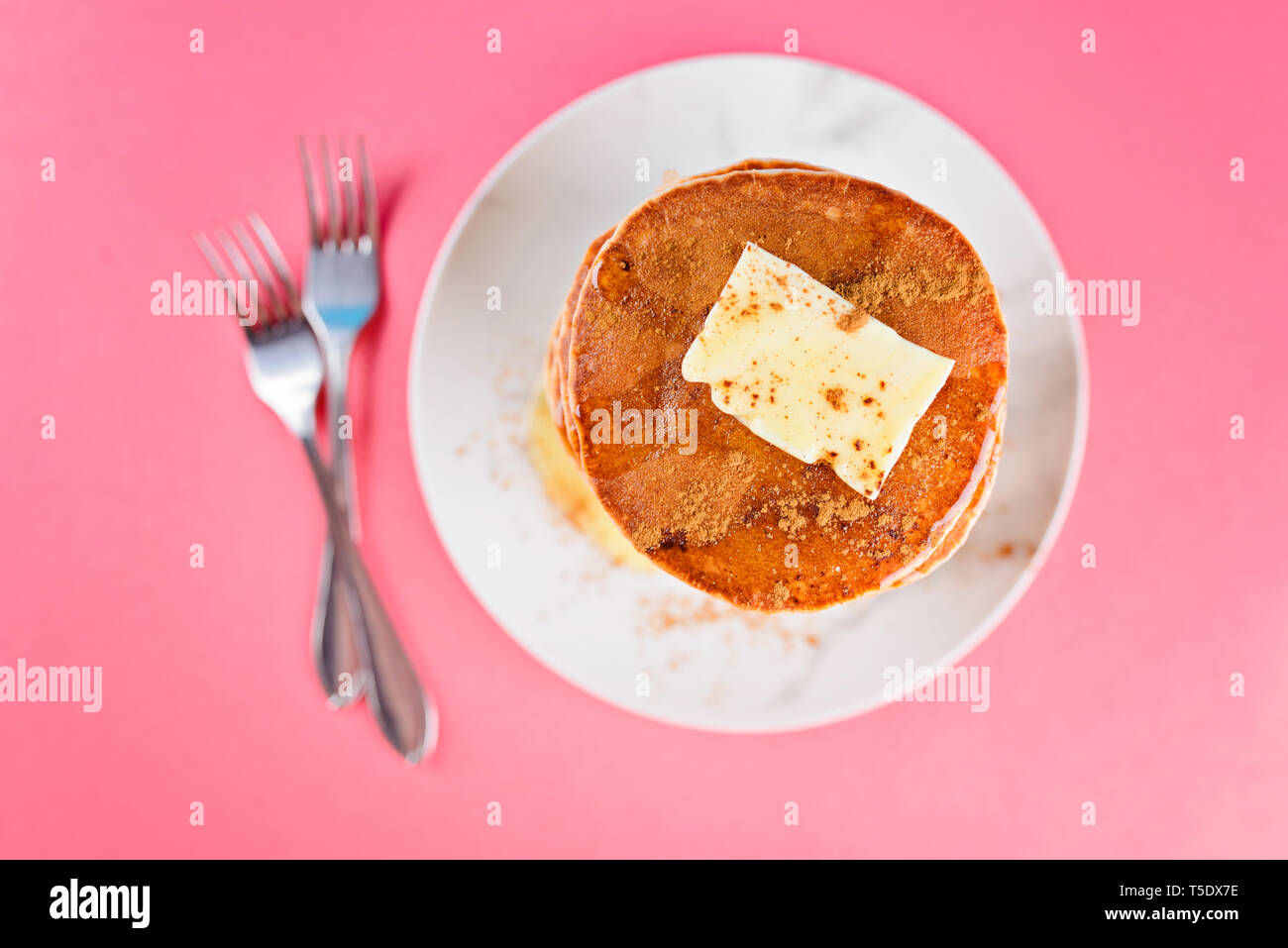 High pile of pancakes with butter, honey, cinnamon on top. Top view. Stock Photo