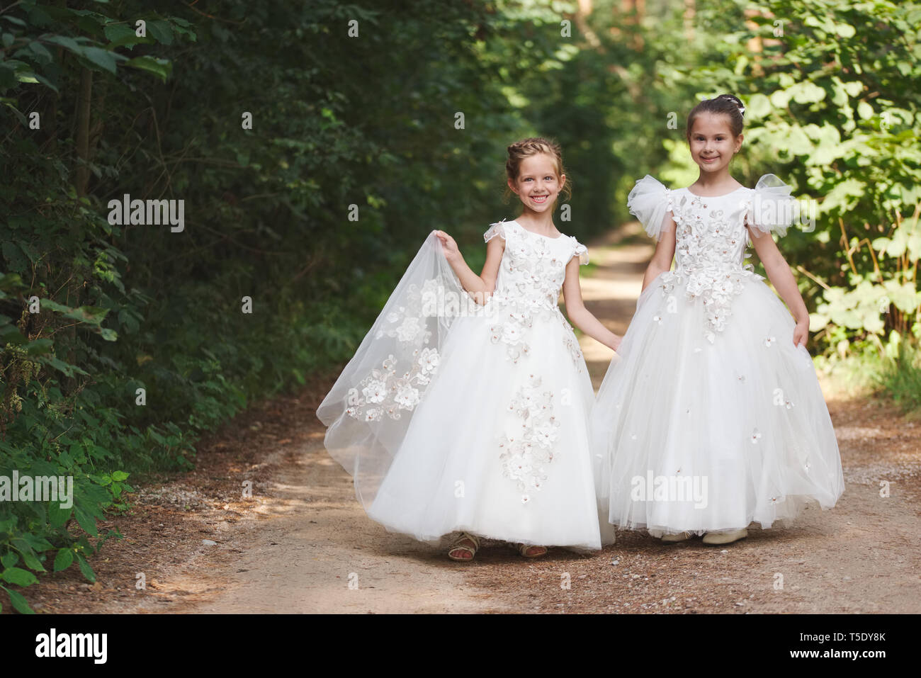 two happy beautiful girls with white wedding dresses Stock Photo - Alamy