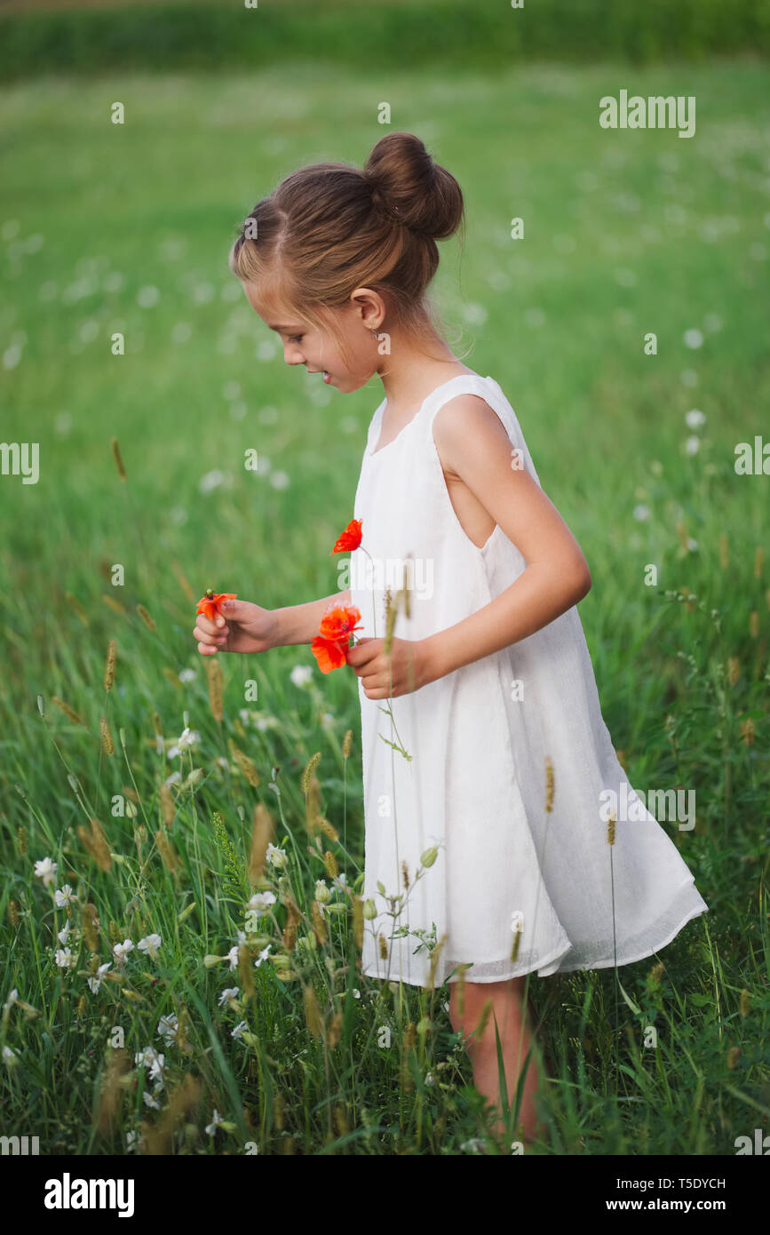 cute little girl with poppy in summer field Stock Photo