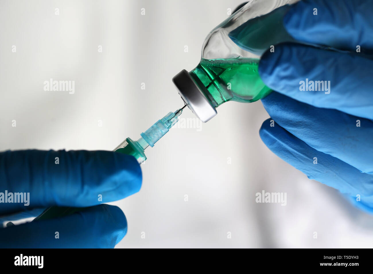 Scientist Holding Green Drug Vaccine Syringe Stock Photo