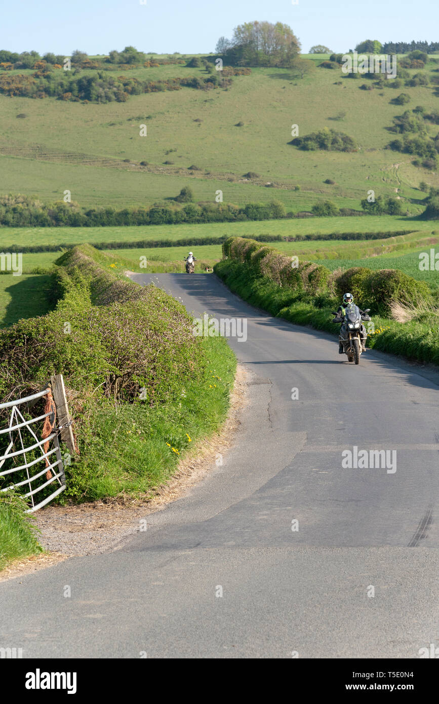 Wiltshire, England, UK, 2019. Motorcyclist returning from an off road trip with the bike covered in dirt and dust travelling through Dorset country Stock Photo