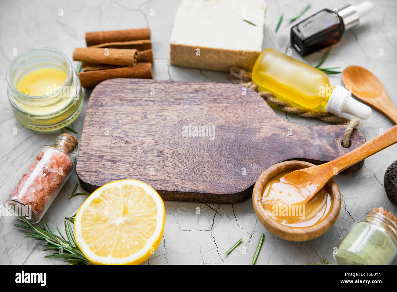 Natural organic ingredients for beauty treatments, home spa setting with wooden board and essential oils, bath salt, rosemary herb, lemon , clay powde Stock Photo