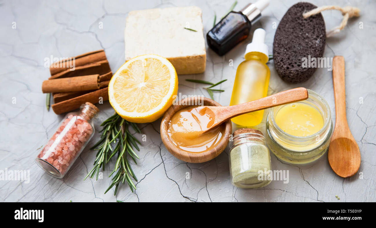 Natural organic ingredients for beauty treatments, home spa setting with essential oil bottles, bath salt, natural soap, rosemary herb, lemon , clay p Stock Photo