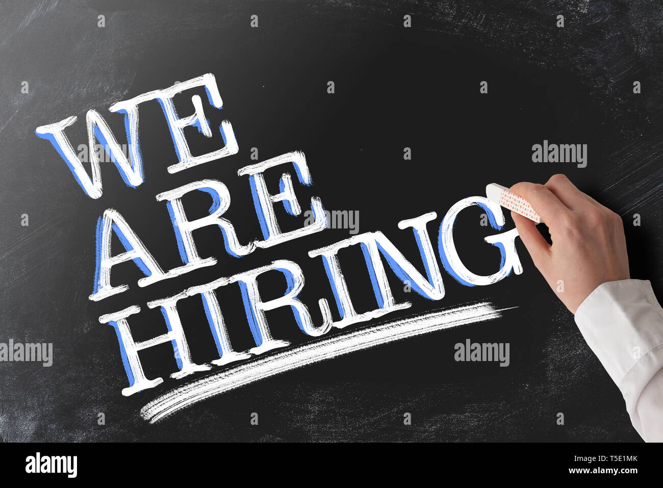 words WE ARE HIRING recruiting concept on blackboard Stock Photo