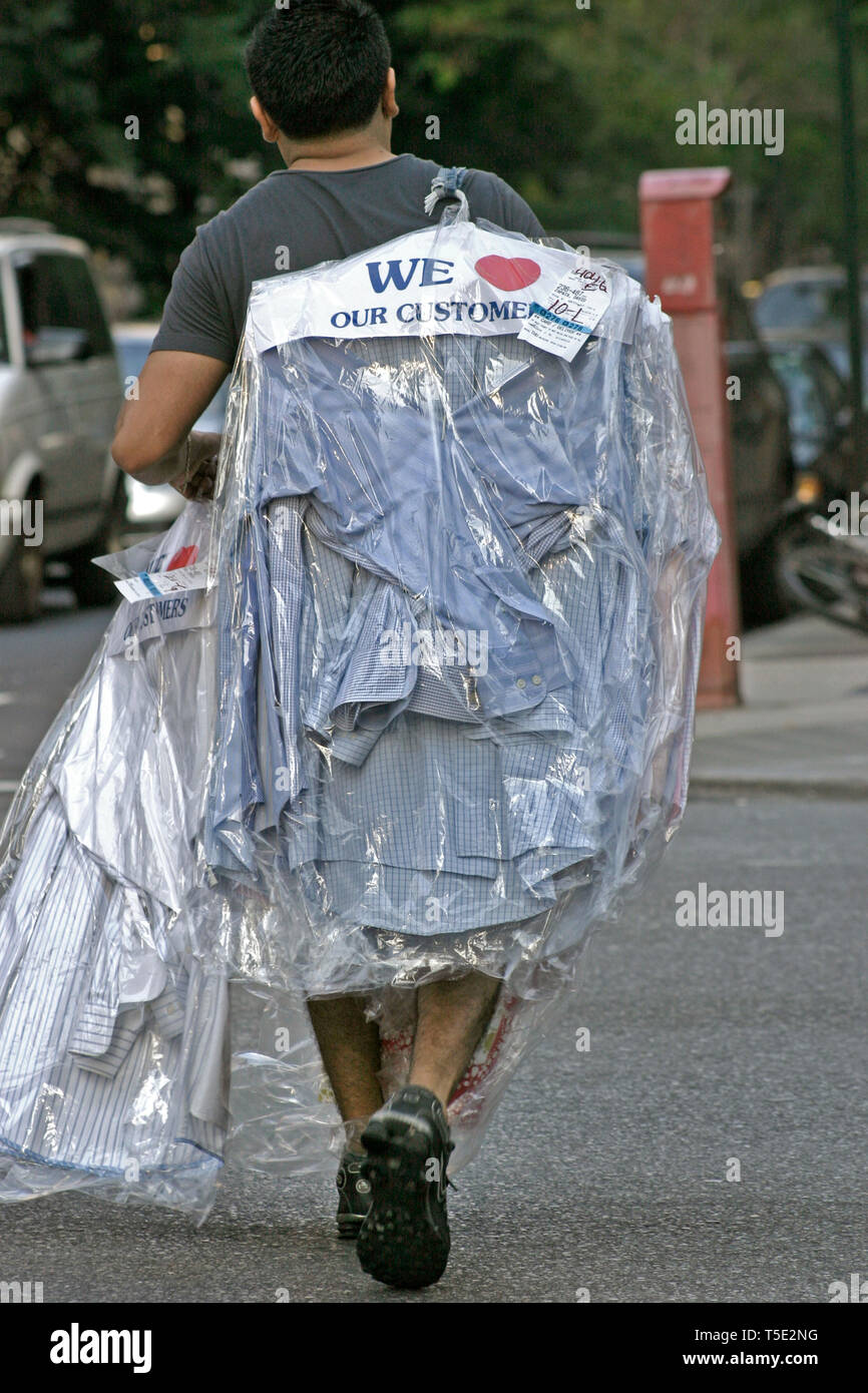 New York City, USA. Man on the street carrying his shirts picked-up from a dry cleaner. Stock Photo